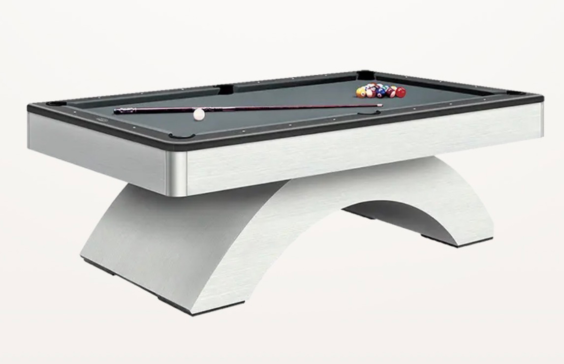 Contemporary white and brushed metal billiard table with a bold arched base, grey felt, and cue stick set on top.
